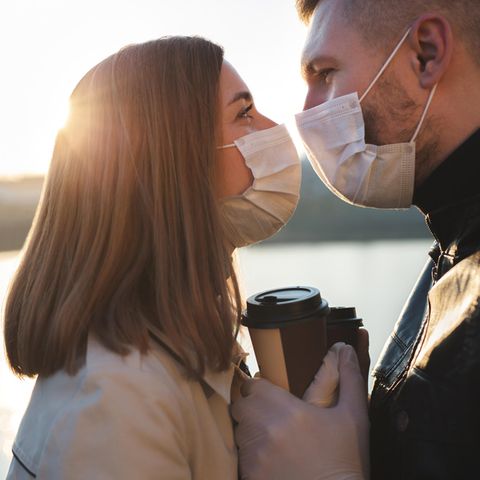 Corona-Dating: Paar küsst sich mit Mundschutz