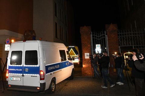 Ein weißer Mercedes Sprinter mit blauem Streifen und "Kriminalpolizei"-Beschriftung fährt im Dunkeln durch ein Backstein-Portal