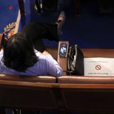 Eine Zuschauerin sitzt allein in einer Stuhlreihe