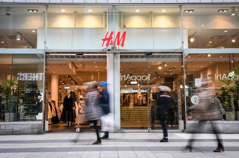 Ein Frau läuft vor einem H&M-Store vorbei