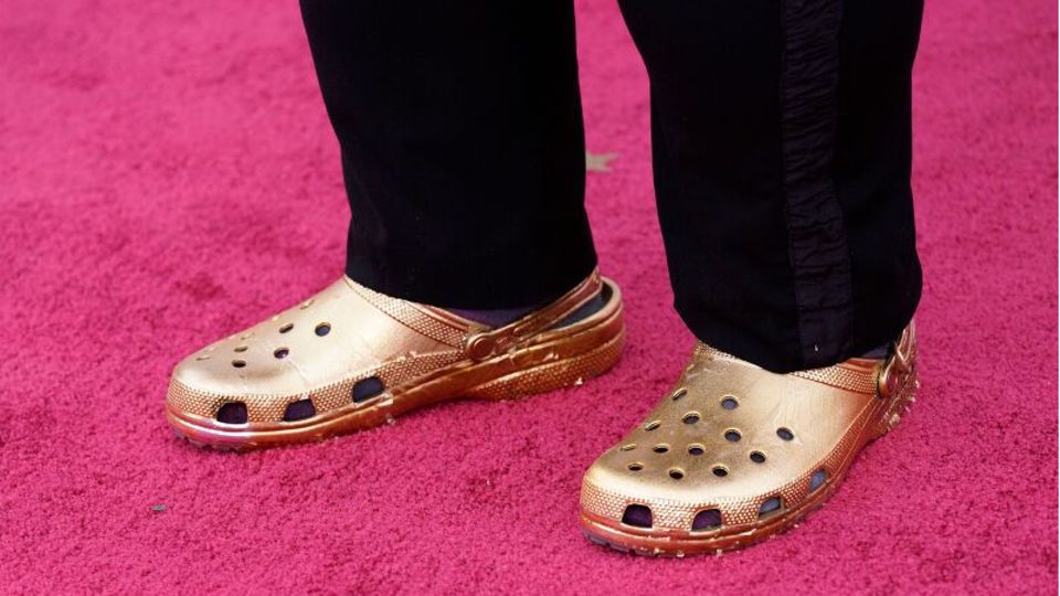 Ein Paar goldener Crocs auf dem roten Teppich der Oscars
