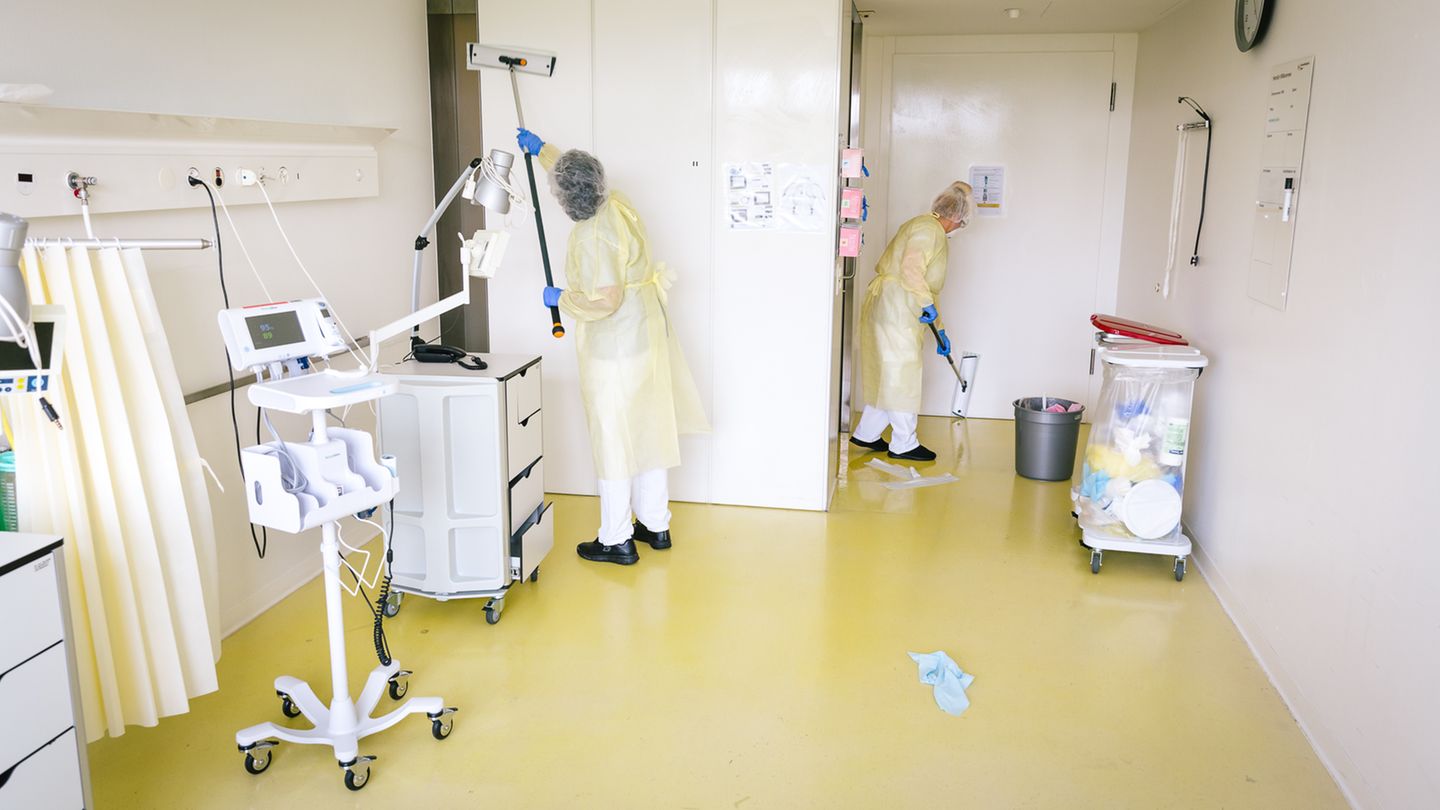 "Auch die Reinigungskräfte arbeiten unter Ansteckungsgefahr" Zwei Frauen reinigen ein Krankenhaus-Zimmer für Covid-Patienten