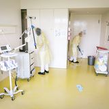 Zwei Frauen reinigen ein Krankenhaus-Zimmer für Covid-Patienten