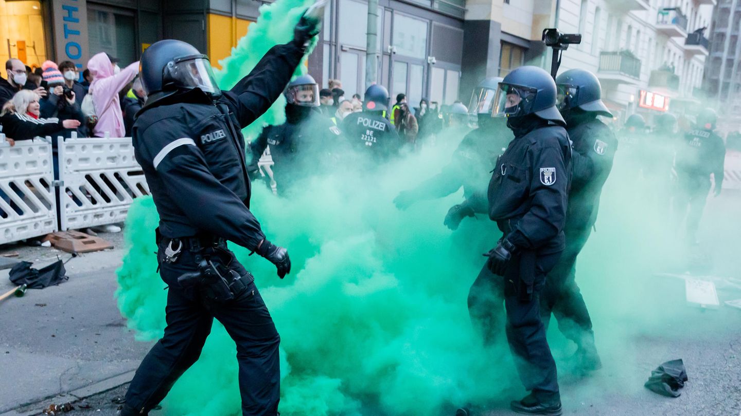 Polizisten versuchen beim Demonstrationszug linker und linksradikaler Gruppen Pyrotechnik zu beseitigen