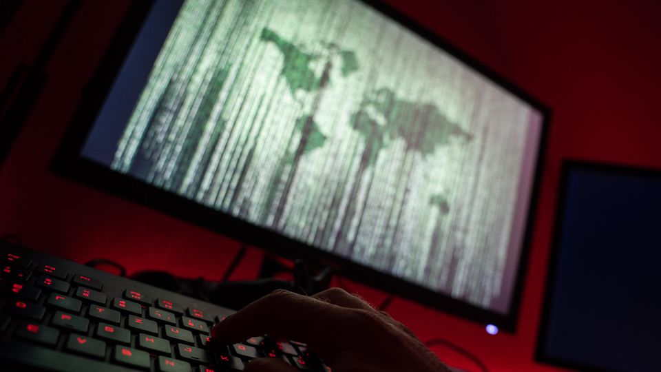 Ein Mann sitzt am Rechner und tippt auf einer Tastatur