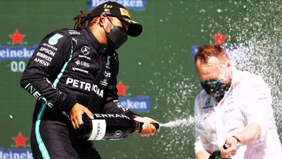 Auf dem Podium in Portimão macht Sieger Lewis Hamilton einen seiner Ingenieure nass