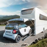 Ein Smart fahrt in die Garage des Morelo Grand Empire Luxuswohnmobils