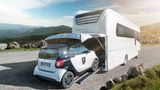 Ein Smart fahrt in die Garage des Morelo Grand Empire Luxuswohnmobils