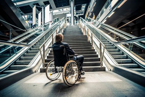 Ein Mann in einem Rollstuhl steht vor einer Treppe