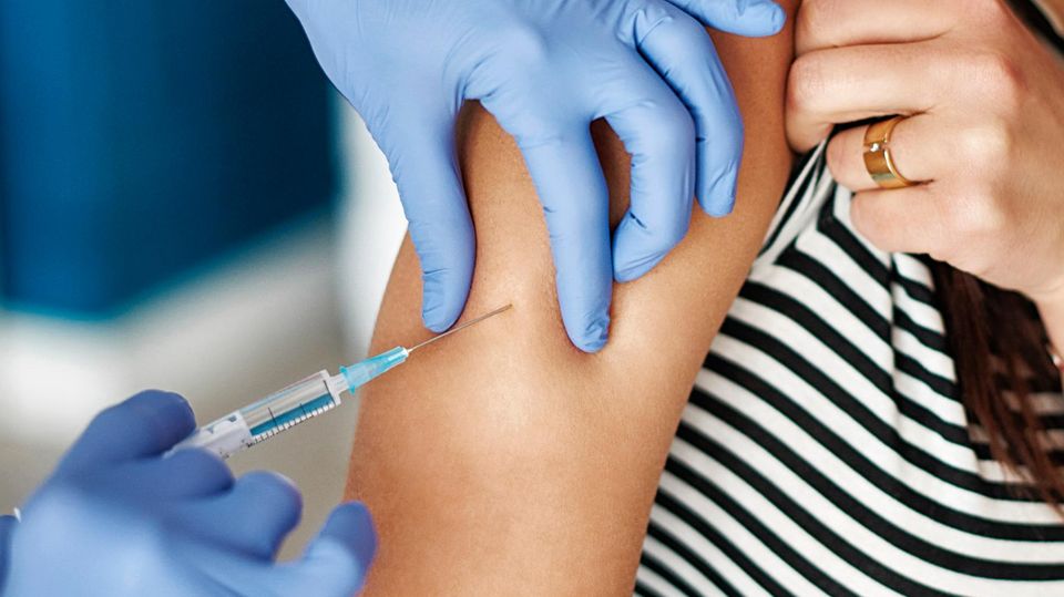 Einer Person wird die Impfung in den Arm verabreicht