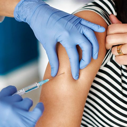 Einer Person wird die Impfung in den Arm verabreicht