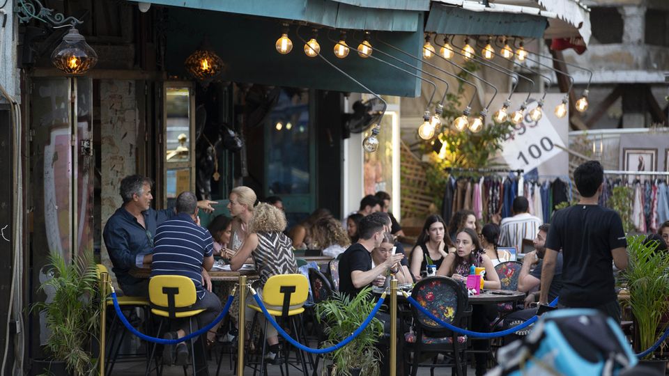 Menschen genießen ihre Zeit in einem Café: Das Tragen von Masken ist in Israel nach einem Rückgang der Infektionsraten in Tel Aviv nicht mehr erforderlich ist