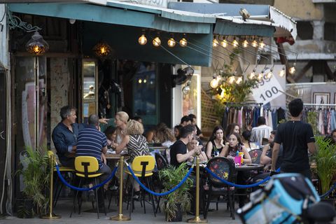 Menschen genießen ihre Zeit in einem Café: Das Tragen von Masken ist in Israel nach einem Rückgang der Infektionsraten in Tel Aviv nicht mehr erforderlich ist