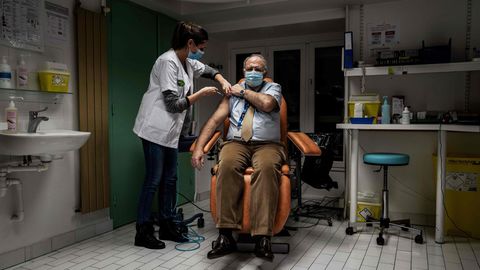 Frankreich, Lyon: Eine medizinische Angestellte injiziert einem Mitglied des medizinischen Personals eine Corona-Impfung