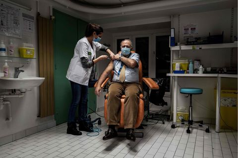Frankreich, Lyon: Eine medizinische Angestellte injiziert einem Mitglied des medizinischen Personals eine Corona-Impfung