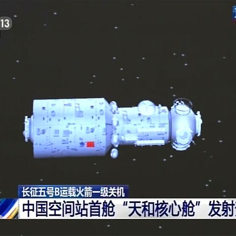 Das Modul einer chinesischen Raumfahrtstation vor einem schwarzen Himmel und chinesischen Schriftzeichen