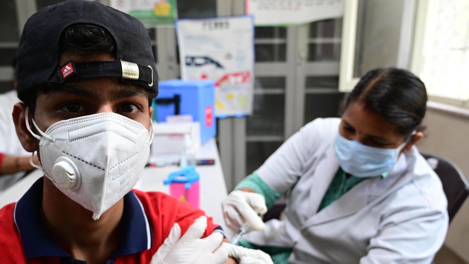 Eine Gesundheitsarbeiterin gibt einem Jungen im indischen Prayagraj die erste Impfdosis