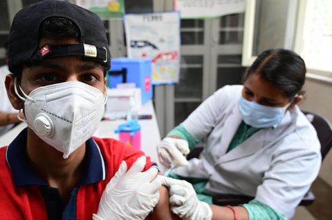 Eine Gesundheitsarbeiterin gibt einem Jungen im indischen Prayagraj die erste Impfdosis