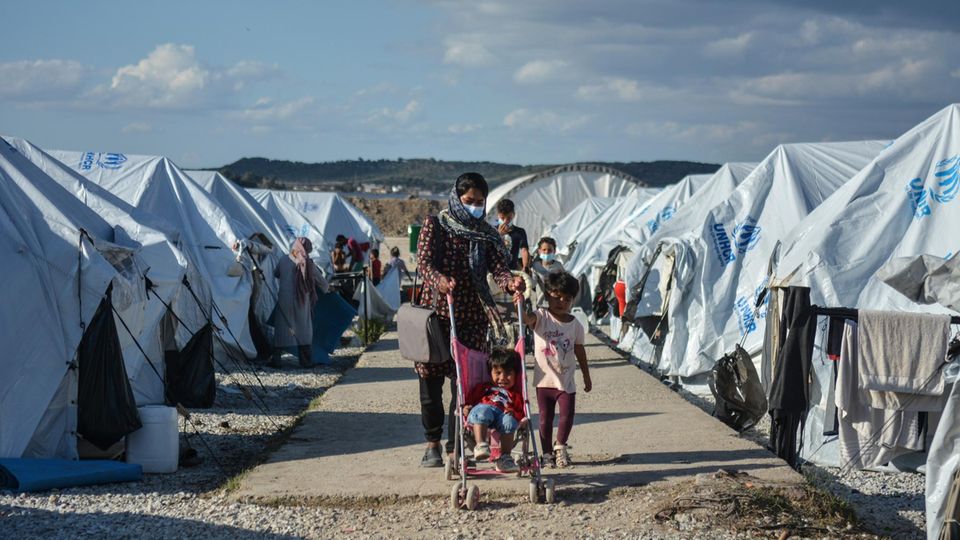 Eine Frau läuft mit ihren Kindern durch das Lager "Kara Tepe" auf der griechischen Insel Lesbos. Eine Frau läuft mit ihren Kindern durch das Lager "Kara Tepe" auf der griechischen Insel Lesbos.