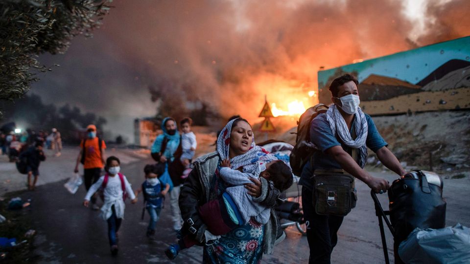 Eine Gruppe Geflüchteter flieht am 9. September 2020 aus dem brennenden Lager Moria auf der griechischen Ägäis-Insel Lesbos. Eine Gruppe Geflüchteter flieht am 9. September 2020 aus dem brennenden Lager Moria auf der griechischen Ägäis-Insel Lesbos.