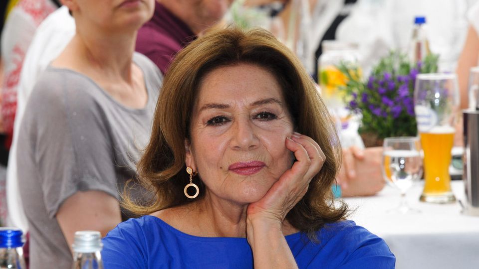 Hannelore Elsner auf einen Porträtfoto, sie trägt ein blaues Top