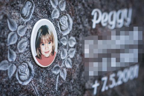 Ein Gedenkstein mit dem Porträt des Mädchens Peggy auf einem Friedhof