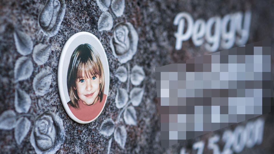 Ein Gedenkstein mit dem Porträt des Mädchens Peggy auf einem Friedhof