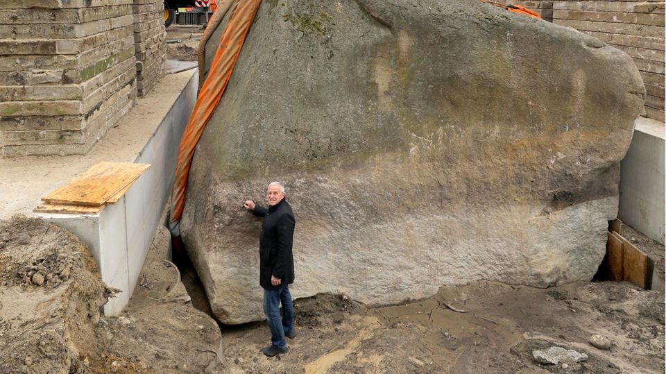 Bürgermeister Volker Bartl steht vor dem Findling