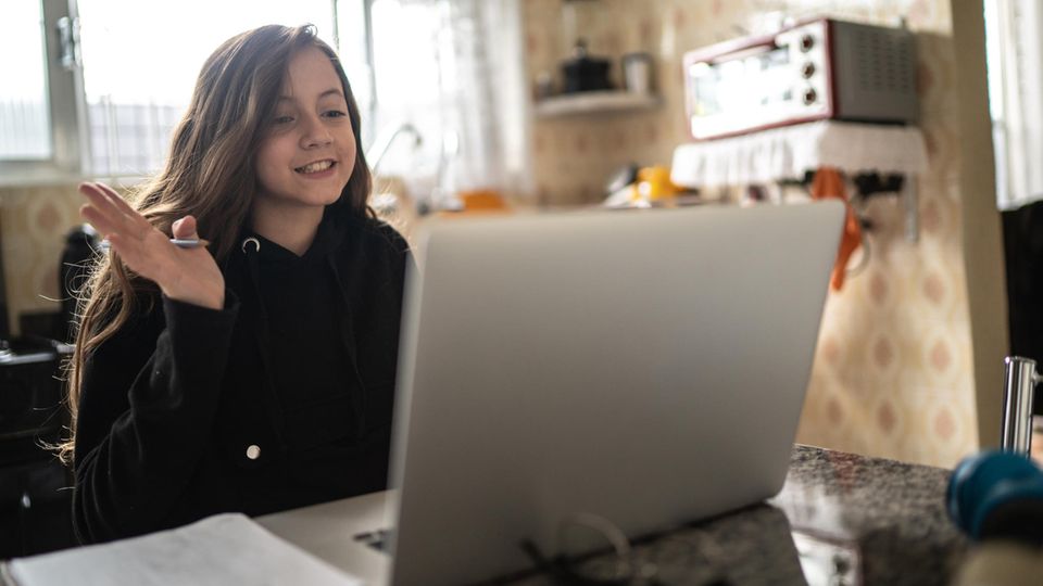 Laptop für Schüler: Ein Mädchen sitzt vor Laptop und nimmt am Unterricht teil.