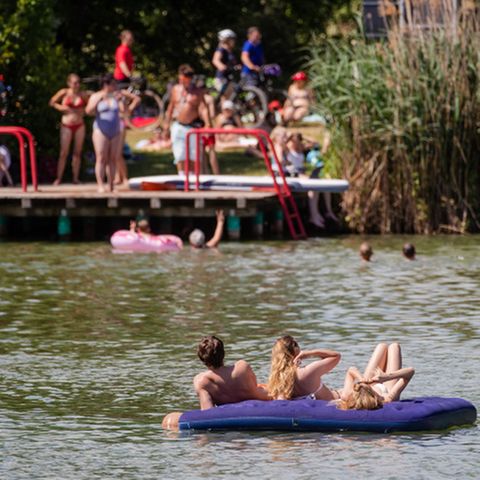 Junge Menschen baden im See