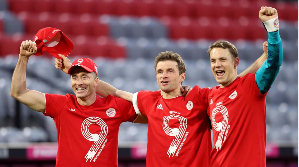 In red T-shirts with a 9 on them, three footballers of FC Bayern Munich celebrate the 9th German Championship in a row