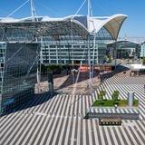 Münchner Airport Center  Vieles unter einem mehr als 40 Meter hohen Dach: Ebenfalls schuf Helmut Jahn die architektonische Verbindung von Terminal 1 und Terminal 2 des München Flughafens. In der offenen Halle befinden sich Restaurants wie das Airbräu, ein Ärztezentrum sowie die Zugänge zu Büroflächen und der S-Bahn. Auf der Freifläche findet im Winter auch ein Weihnachtsmarkt statt.