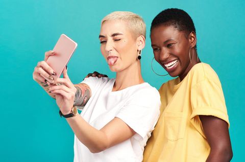 Preis Leistung Smartphone: Zwei Frauen machen ein Selfie. Die vordere streckt