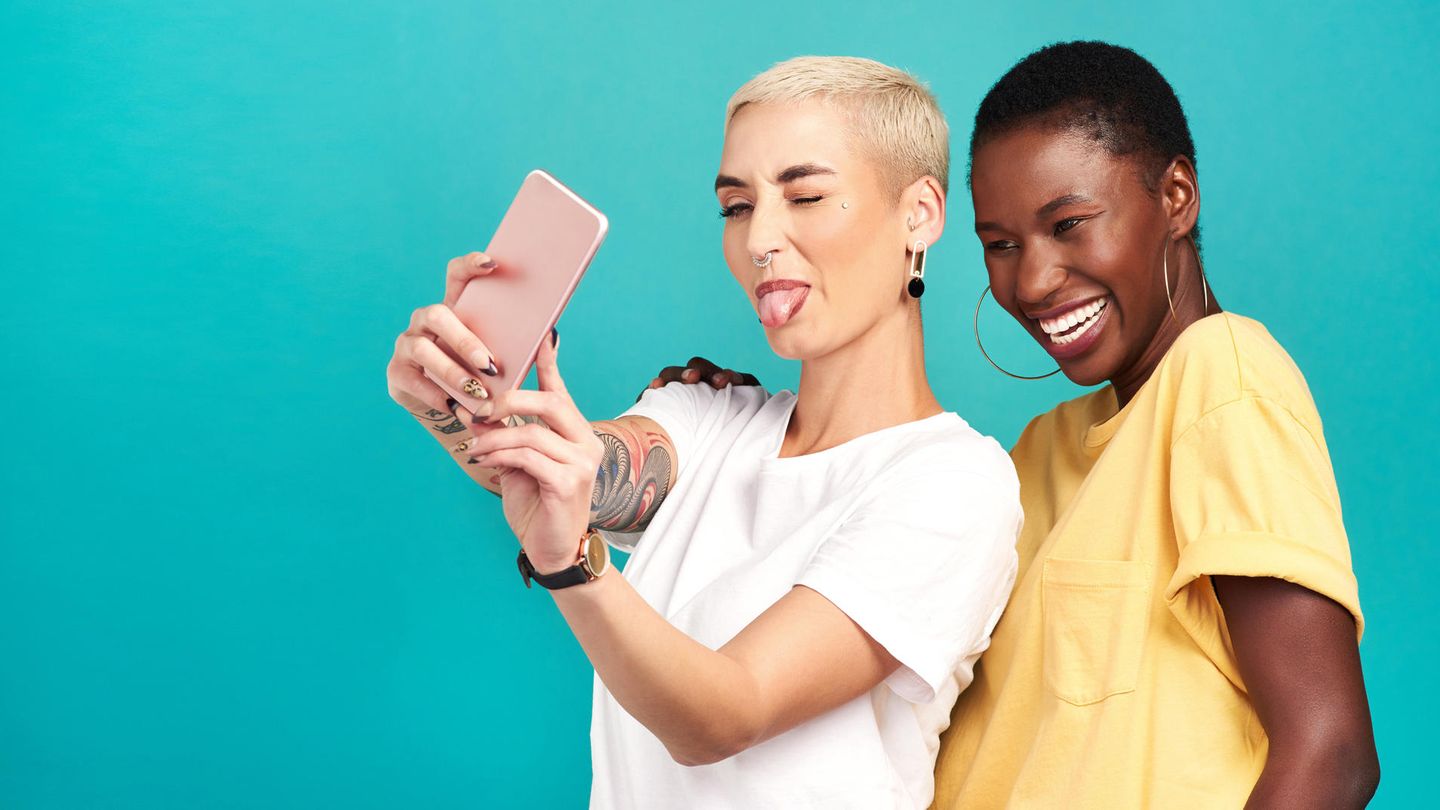 Preis Leistung Smartphone: Zwei Frauen machen ein Selfie. Die vordere streckt