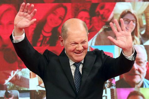 Kanzlerkandidat Olaf Scholz hebt die Hände und lächelt auf dem SPD-Bundesparteitag