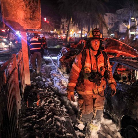 Feuerwehrmann geht durch Zerstörungen durch einen Raketneinschlag nahe Tel Aviv