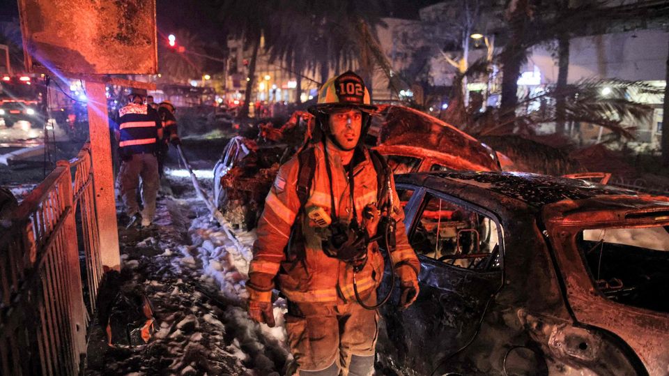 Feuerwehrmann geht durch Zerstörungen durch einen Raketneinschlag nahe Tel Aviv