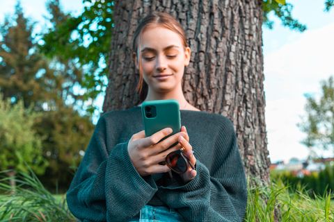 Junge Frau mit ihrem Handy in der Hand