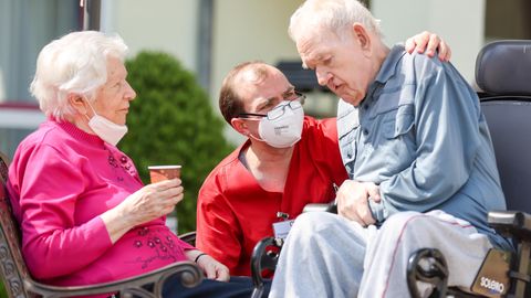 Ein Pfleger kümmert sich um ein altes Paar