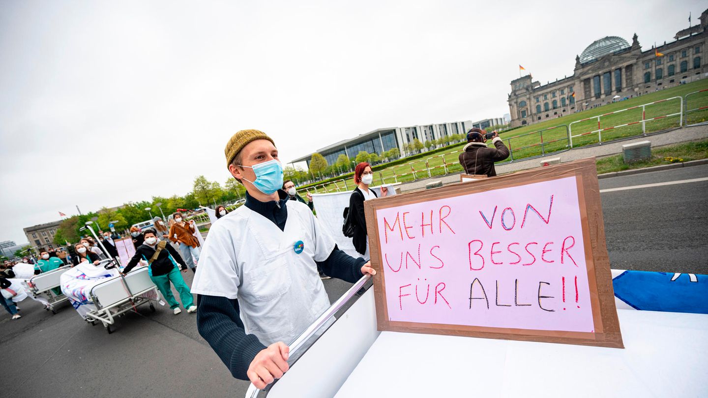 Ein Teilnehmer der Aktion "Der Pflege geht die Luft aus" geht mit einem Krankenhausbett am Reichstagsgebäude vorbei