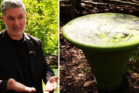 Mann stehet neben grünen Plastikmöbeln in einem Park
