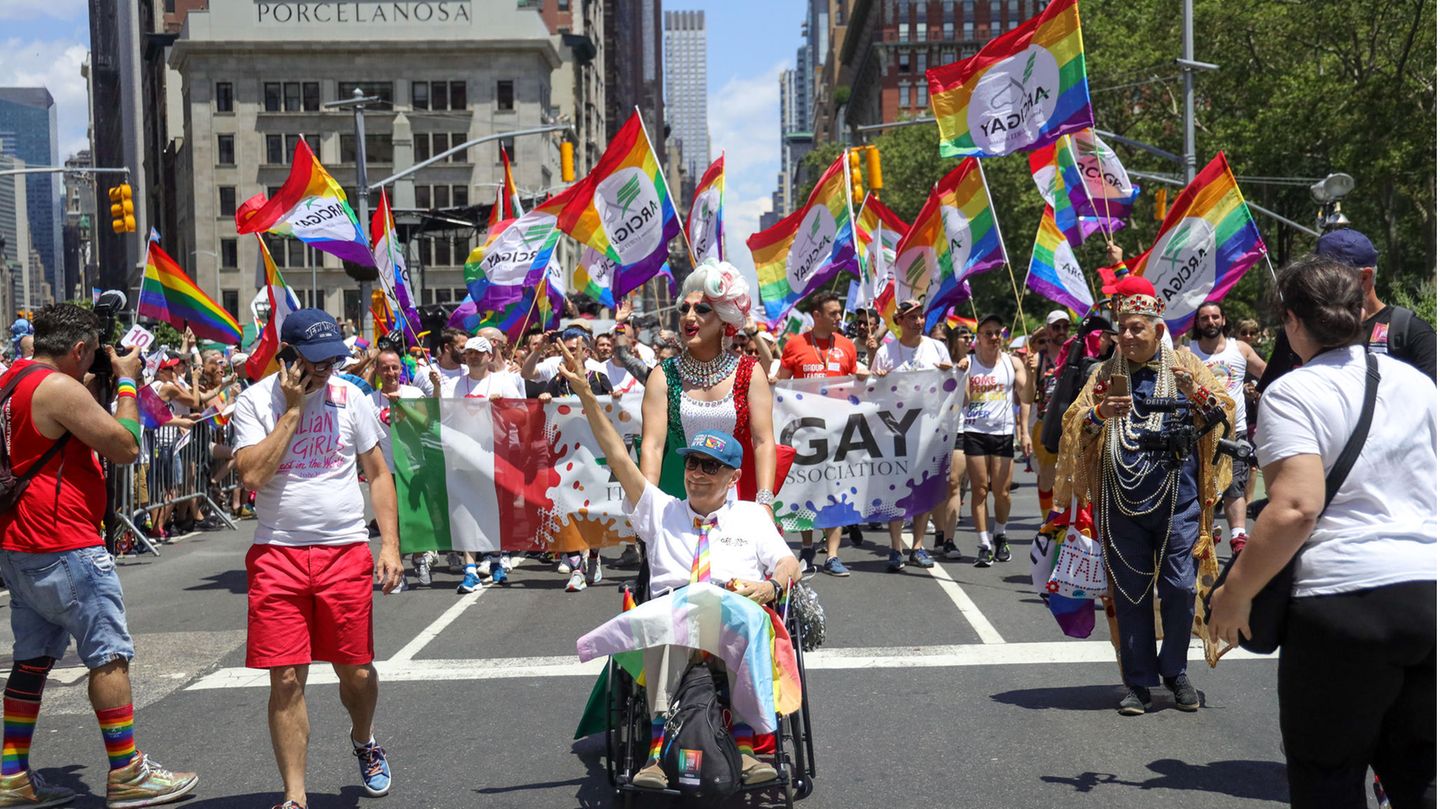 Menschen nehmen an der Pride-Parade in New York teil und schwenken Regenbogen-Flaggen