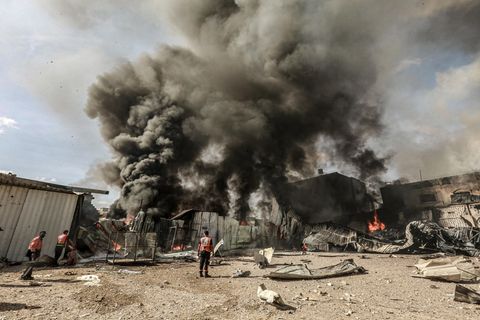 Mitglieder der palästinensischen Zivilverteidigung versuchen, das Feuer in einer Schaumstofffabrik zu löschen