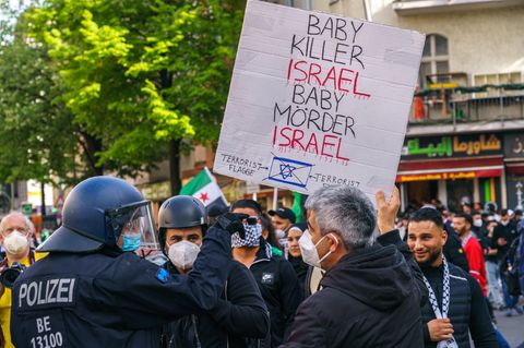 Demonstranten halten in Berlin ein Schild "Babymörder Israel"