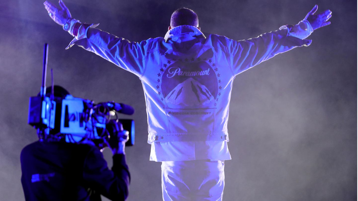 Der Rapper Sido steht mit ausgebreiteten Armen vor einer Kamera auf der Bühne.