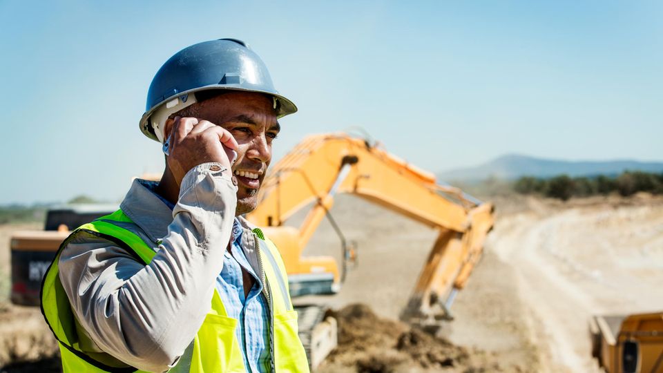 Ein Architekt telefoniert mit seinem Baustellen-Handy.