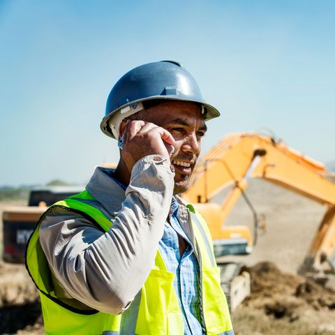 Ein Architekt telefoniert mit seinem Baustellen-Handy.