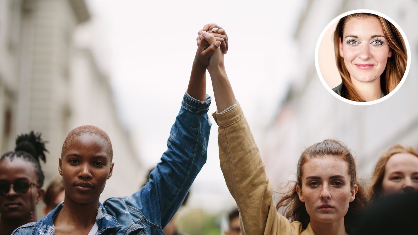 Zwei Frauen recken kämpferisch die Hände in die Höhe
