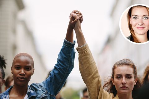 Zwei Frauen recken kämpferisch die Hände in die Höhe