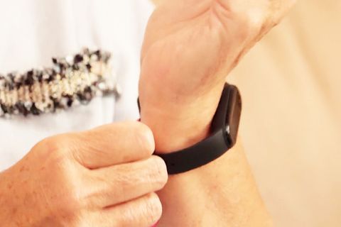 Person legt Fitnesstracker an das Handgelenk an